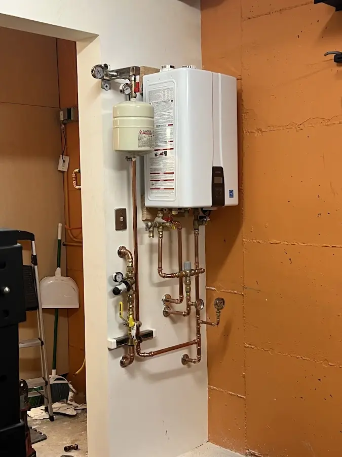 Plumbing technician inspecting water heater connections in Williamsburg